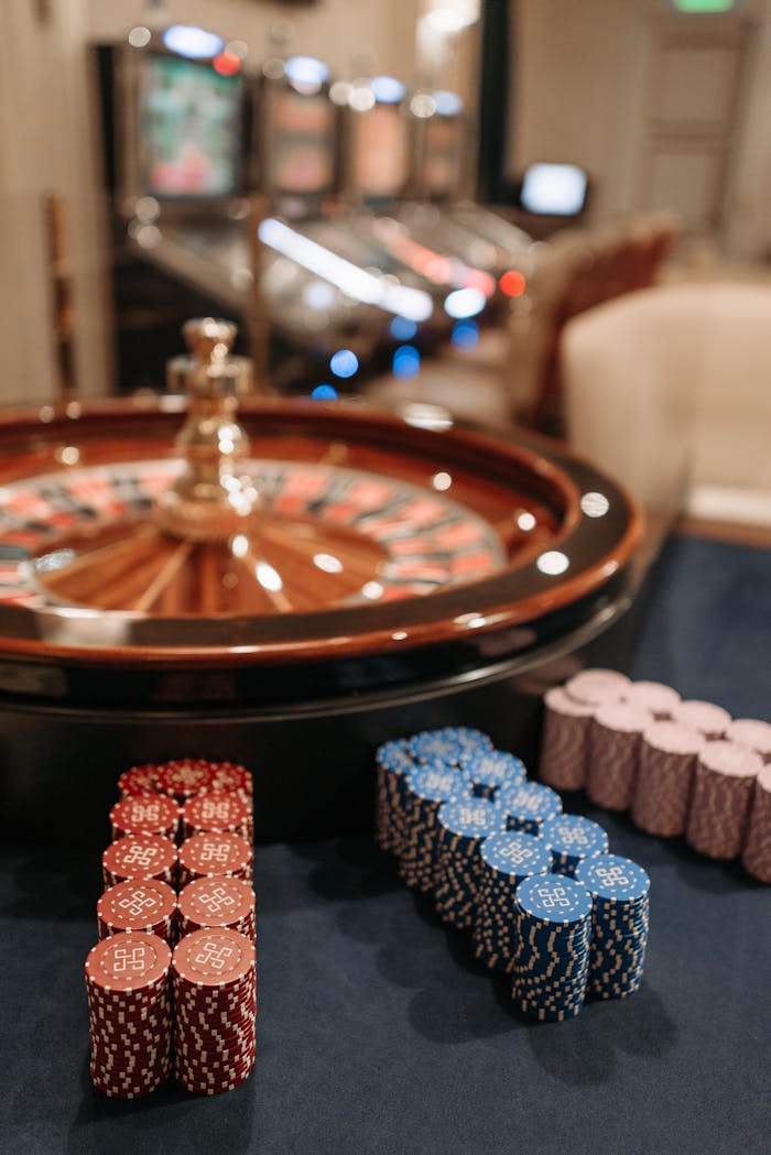 Stacks of Casino Tokens Beside a Roulette